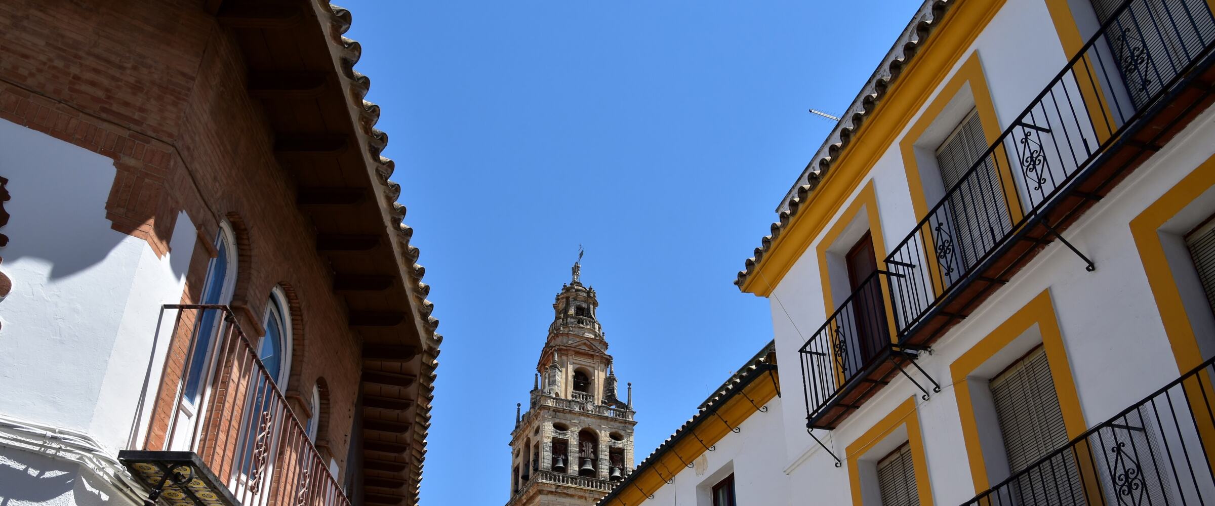 Calle encalada del casco antiguo de Córdoba con balcones de forja